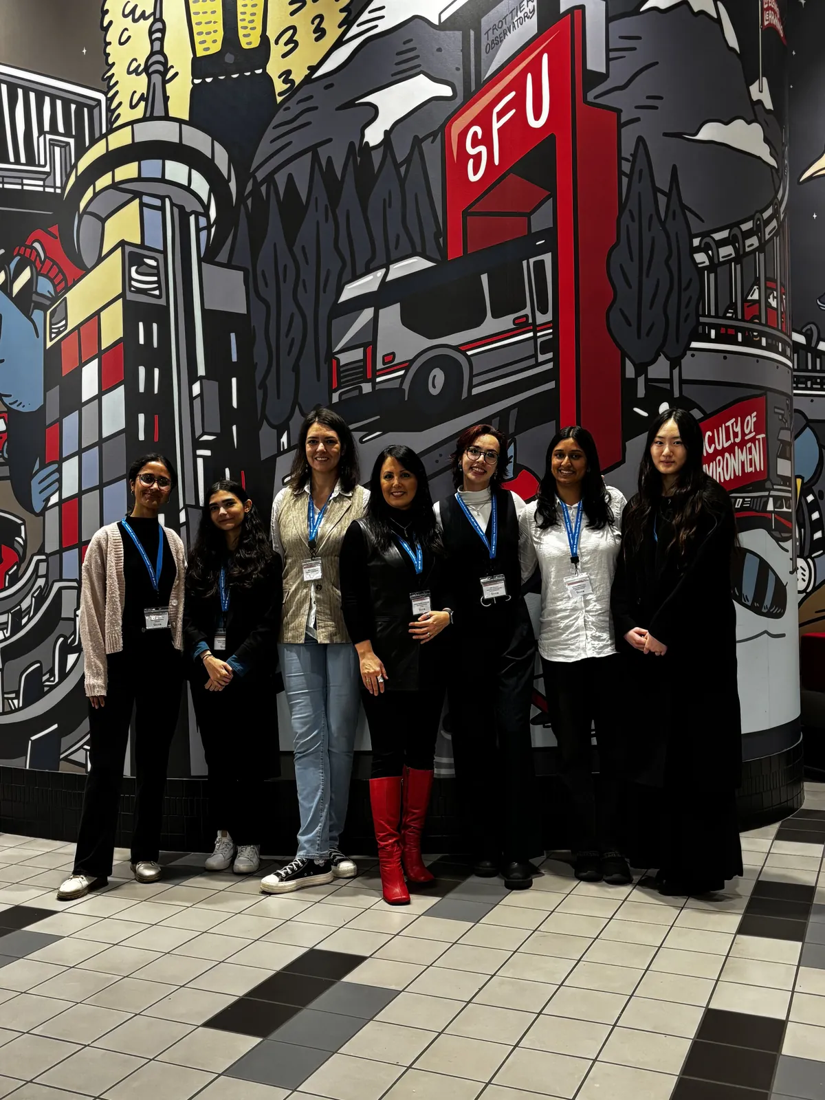CAN-CWiC West 2025 organizing team members posing in front of the SFU mural at Harbour Centre
