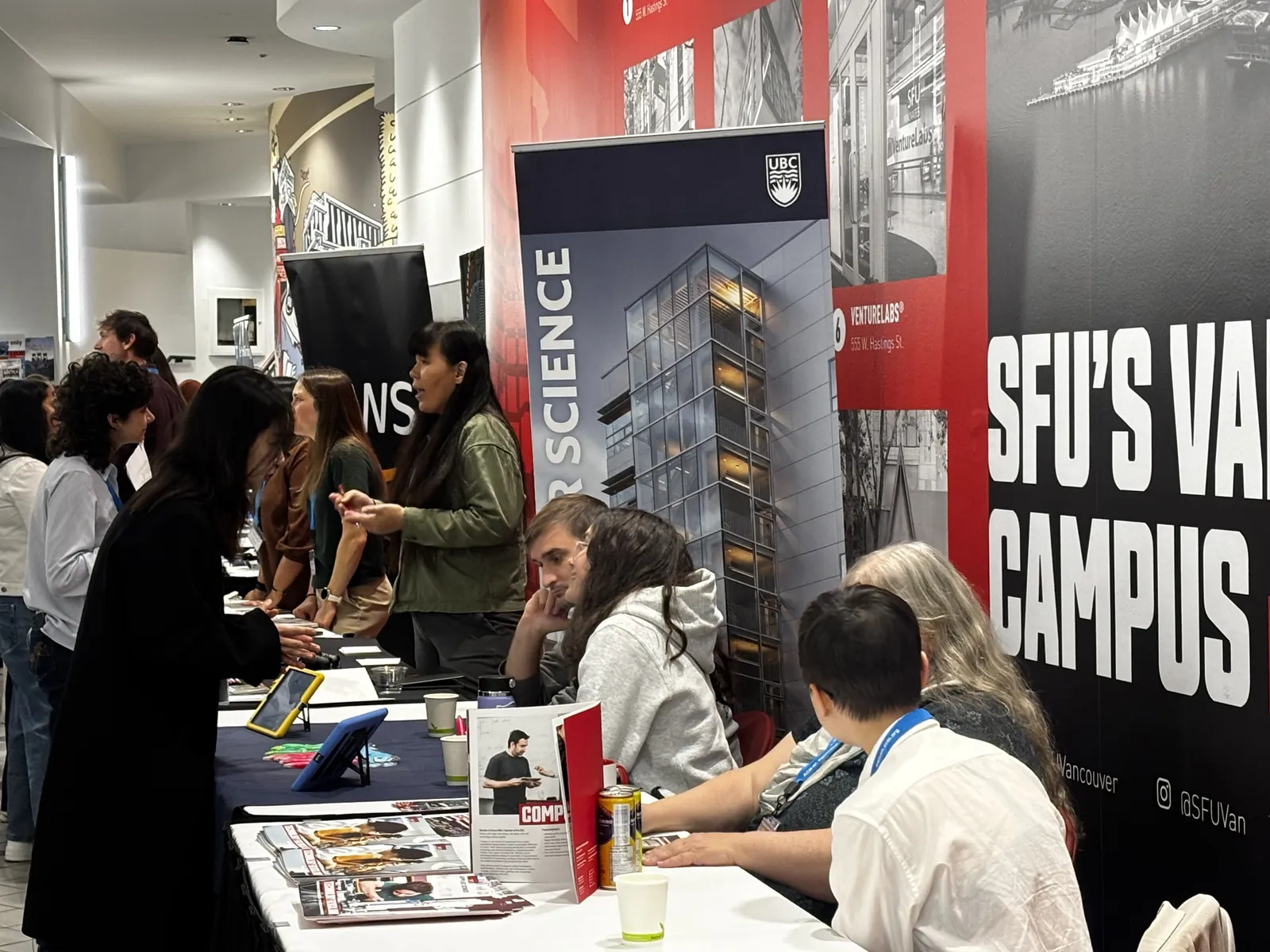 Students speaking with sponsors at the UBC Computer Science and Northeastern University booths during CAN-CWiC West 2025